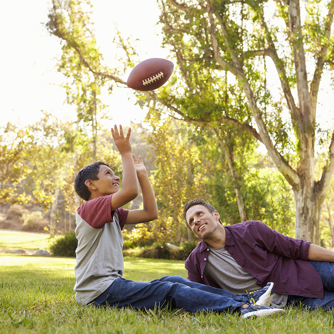 Man with child throwing football