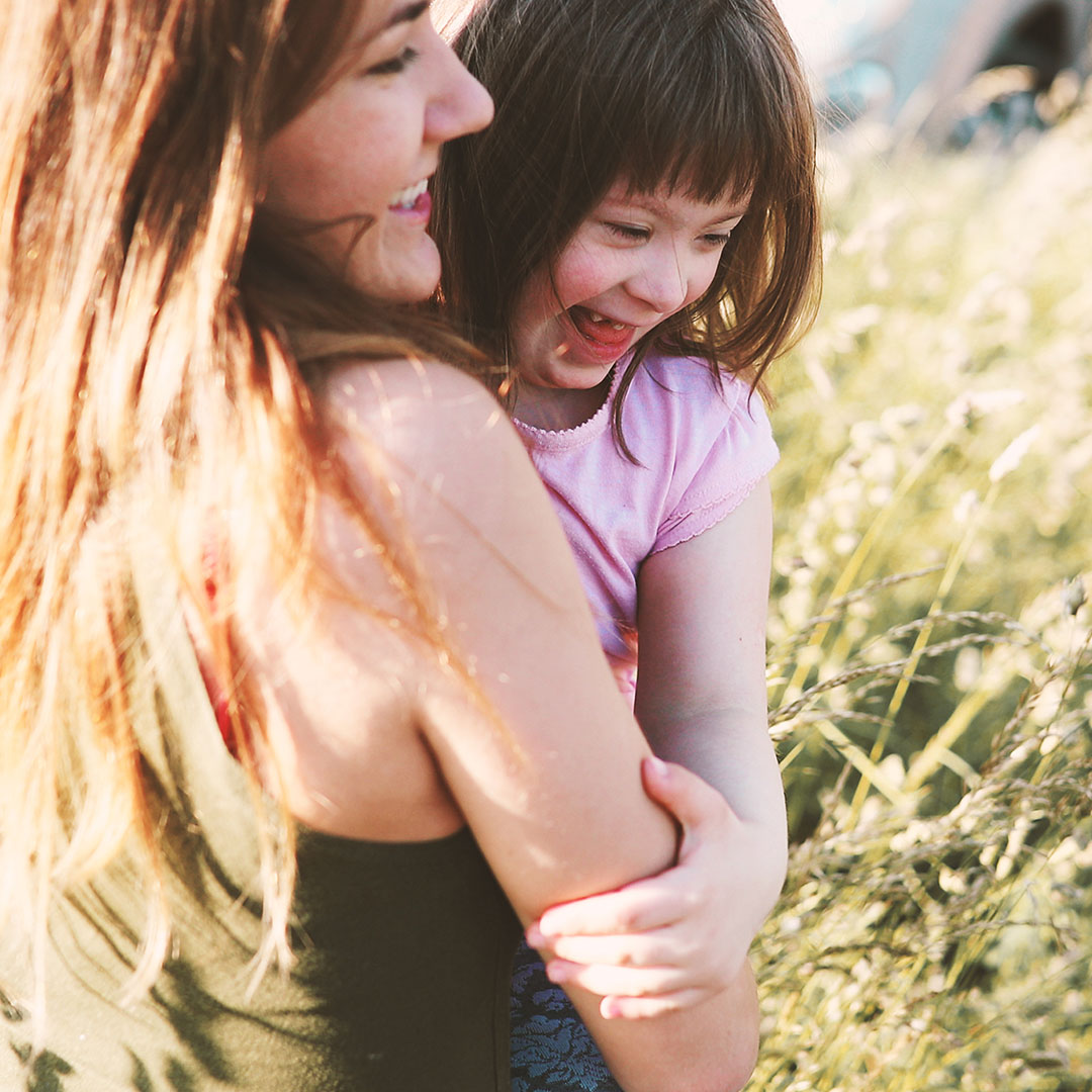 Woman holding child in a field