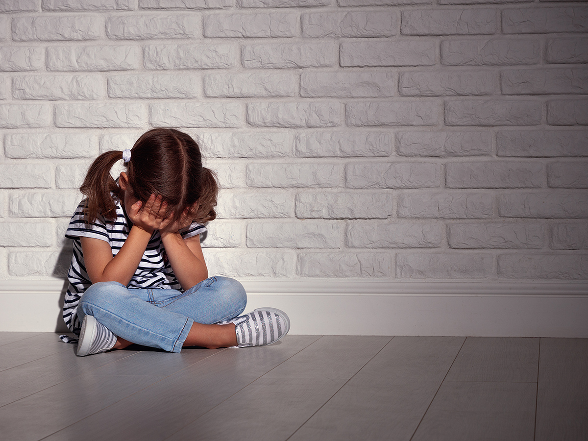 Child covering face with hands