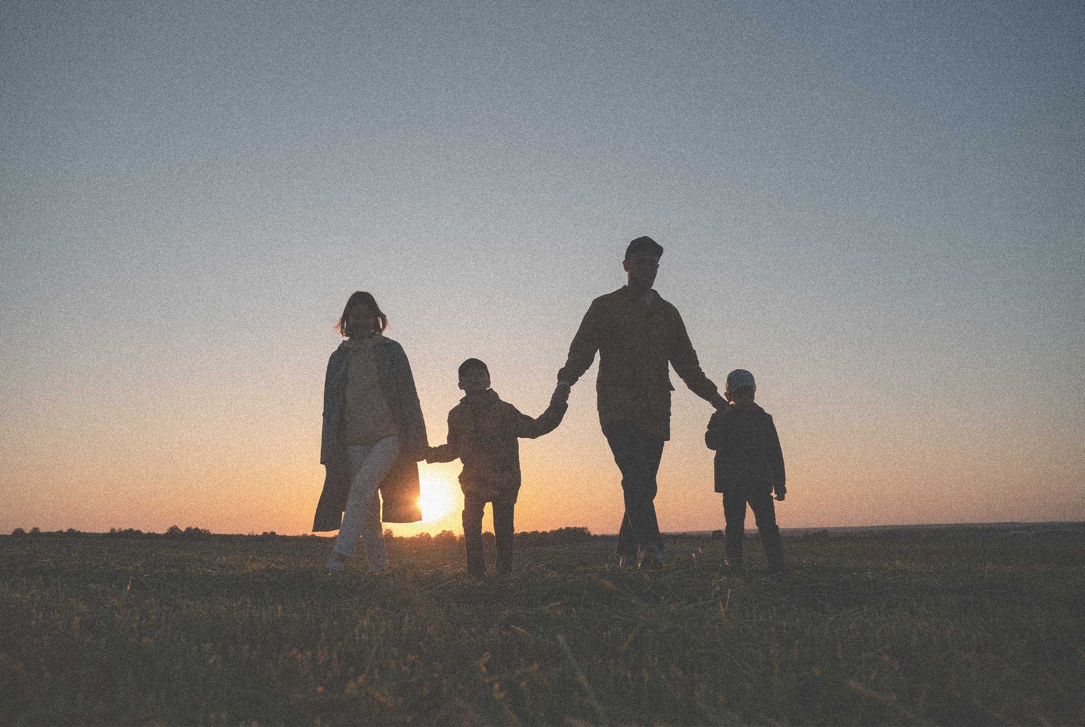 Family holding hands at sunset