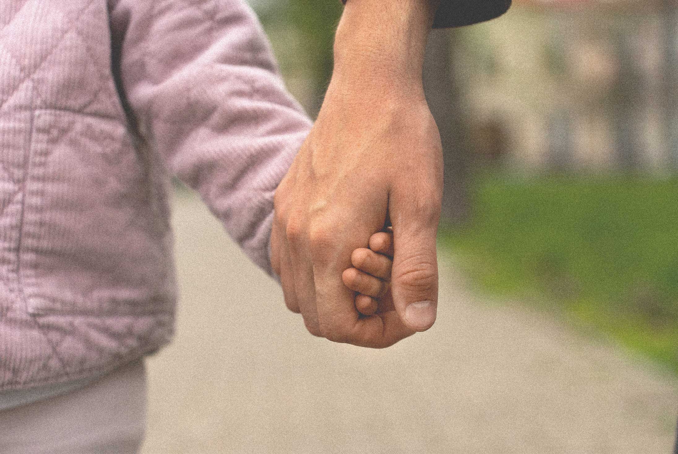 Adult and child holding hands