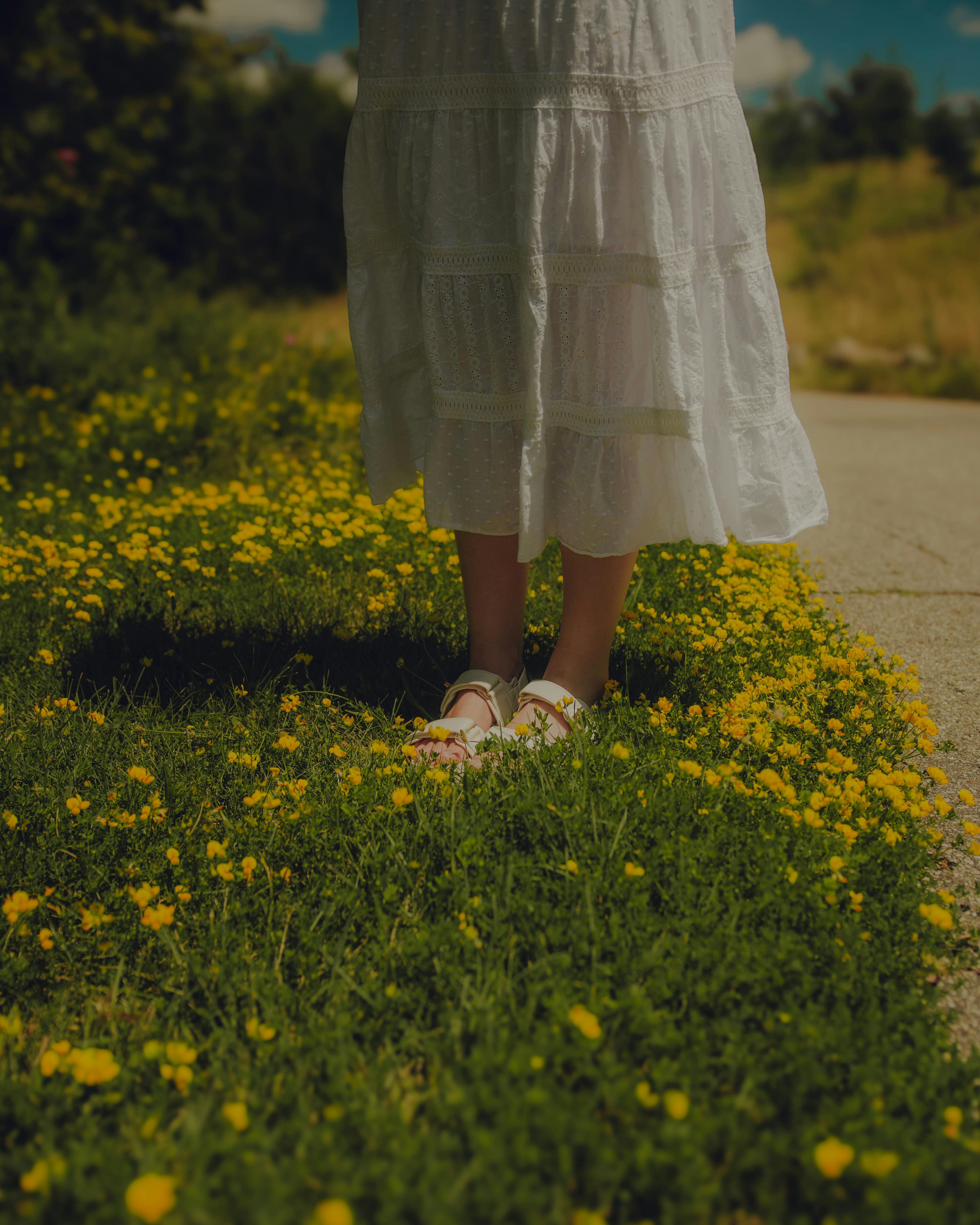woman in skirt standing in wildflowers