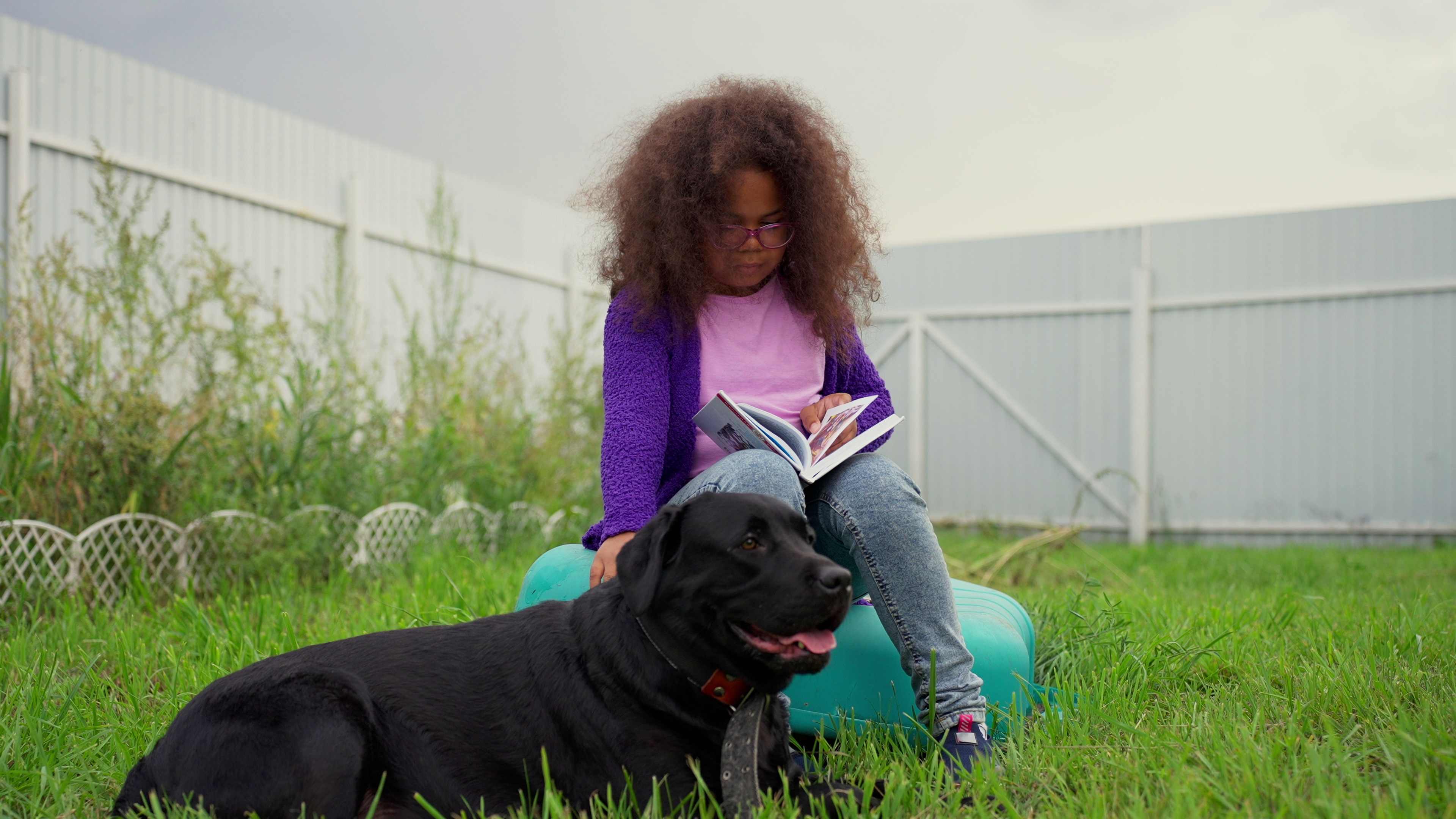 girl reading with large dog