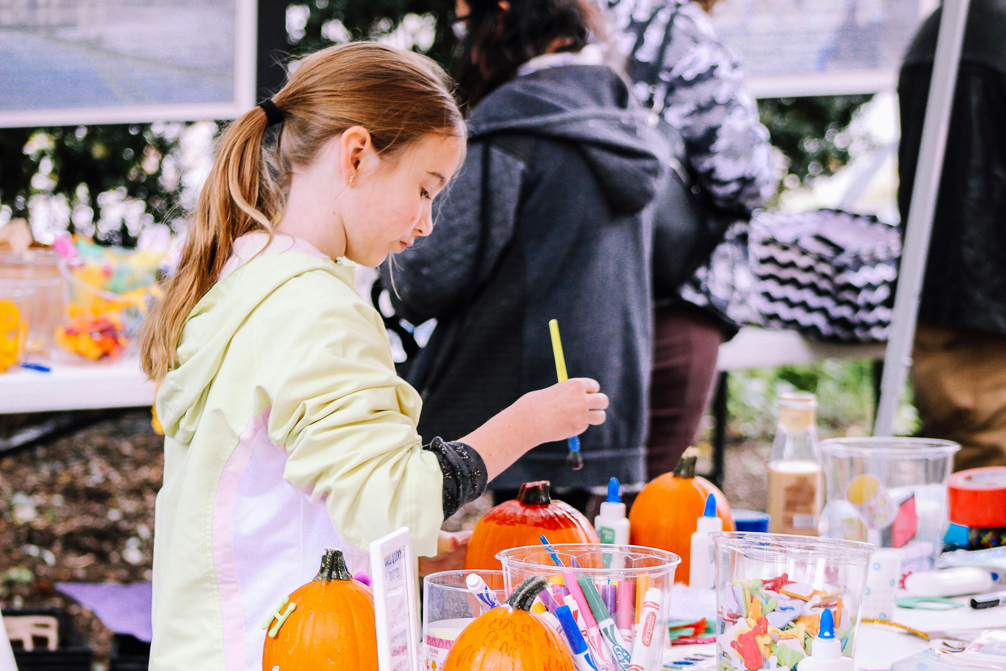 child painting a pumpkin