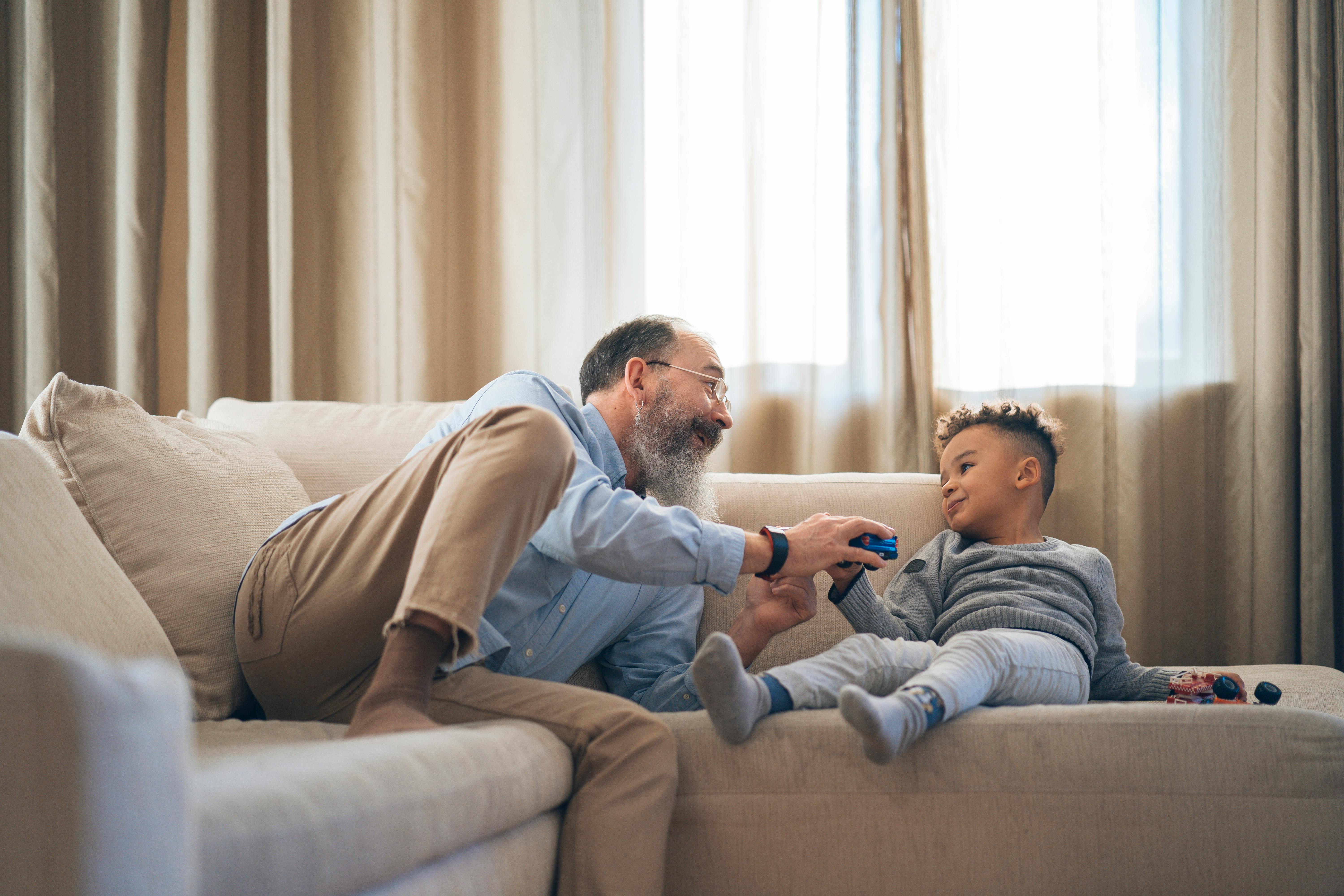 man and child playing on the couch