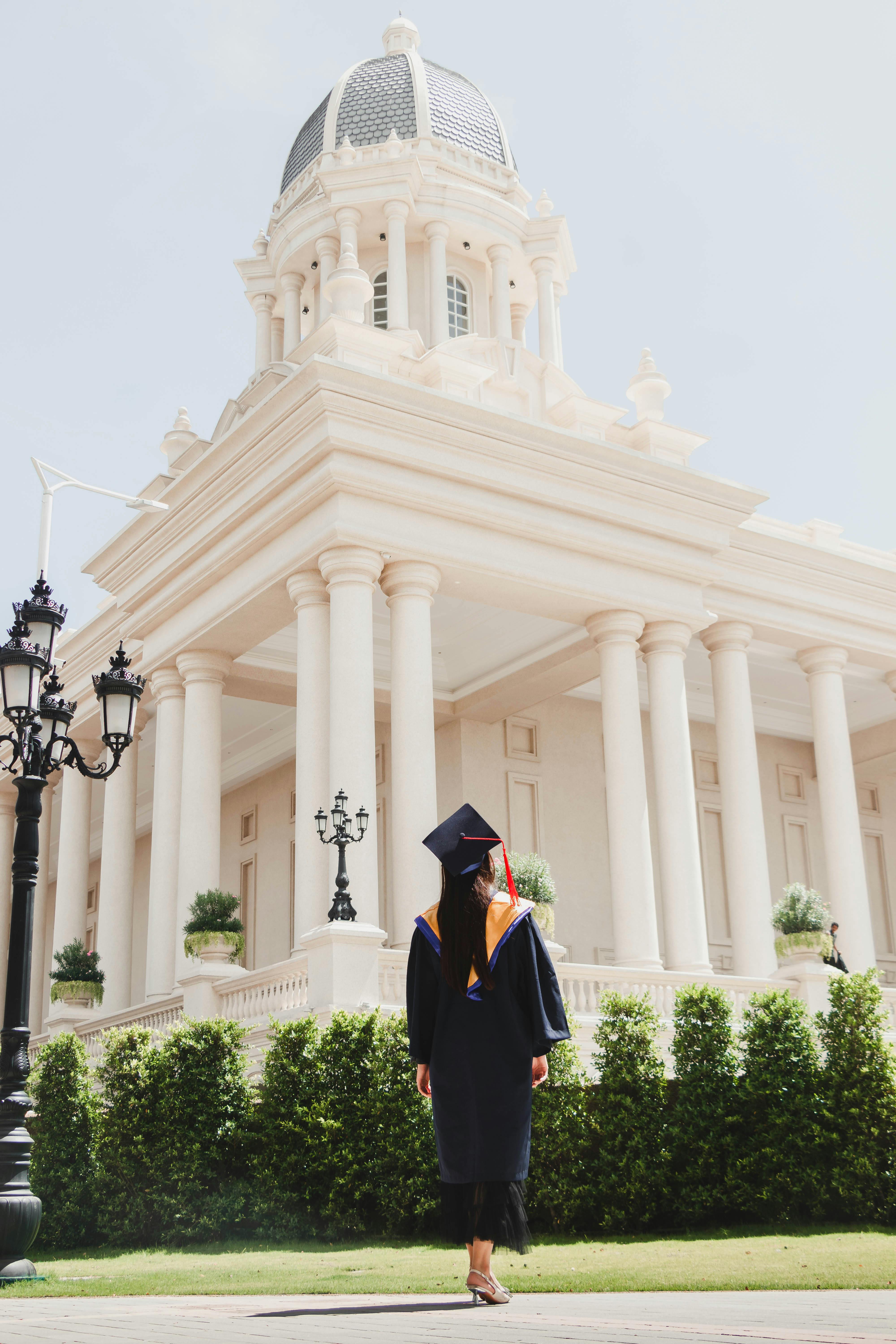 graduate in front of college building