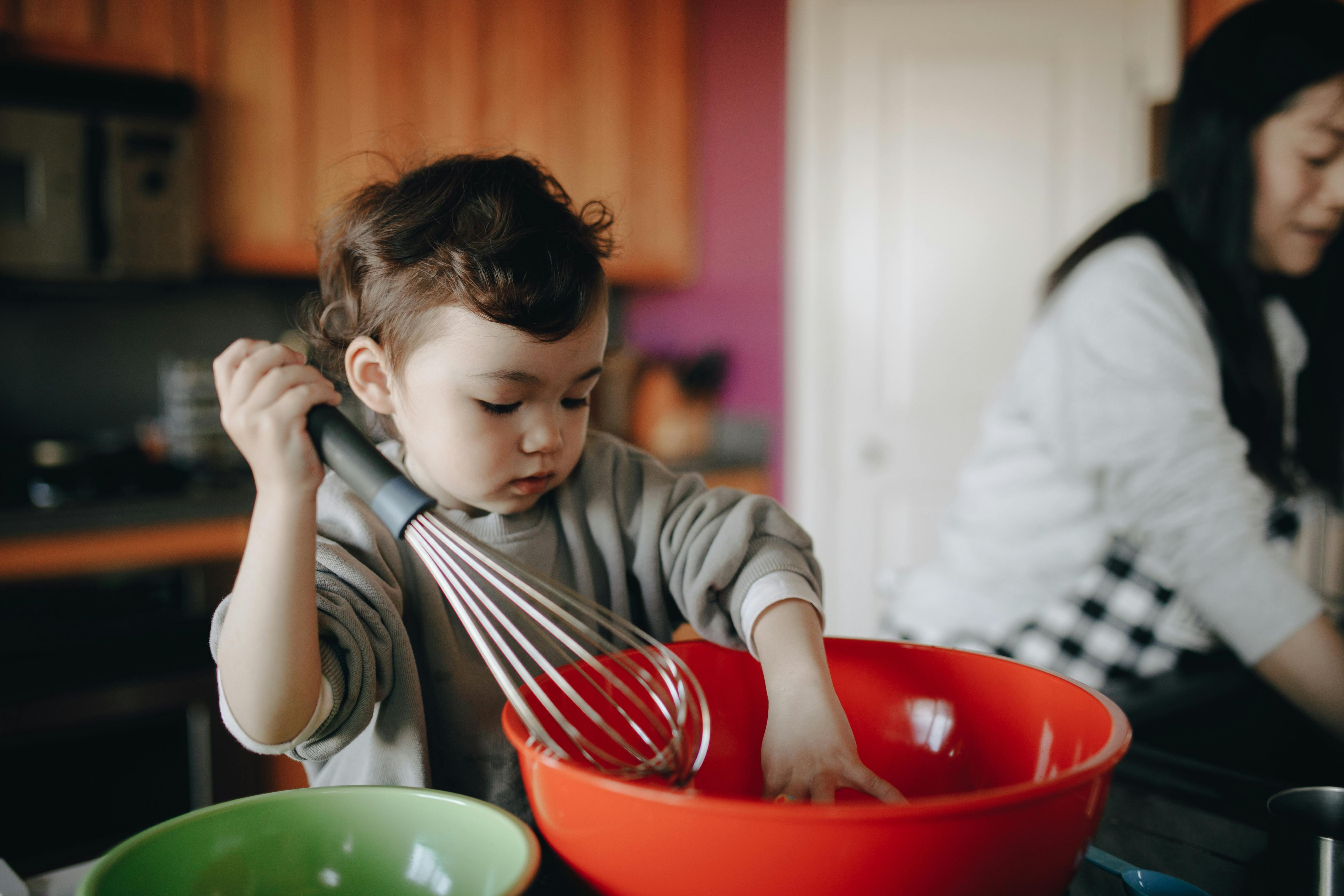 Child stirring with a whisk