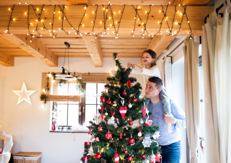 Man and child decorating a Christmas tree