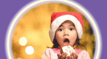 Child in a Santa Hat holding a present