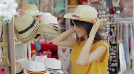 woman trying on hats in a boutique