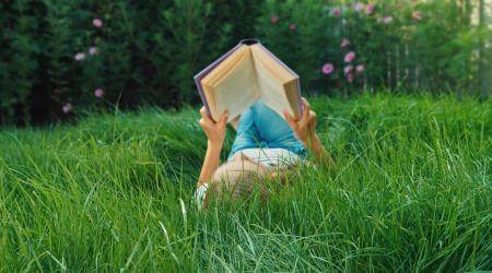 girl with book in the grass