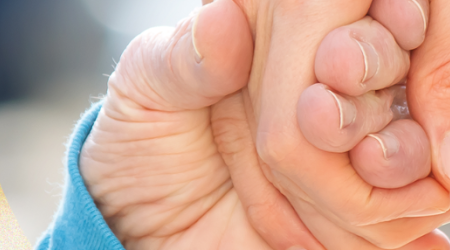 child and adult holding hands