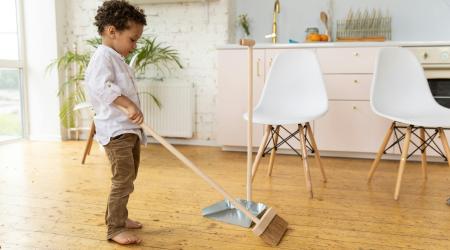 young boy sweeping the floor