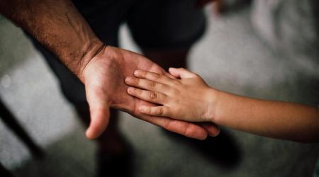 Child's hand on father's hand