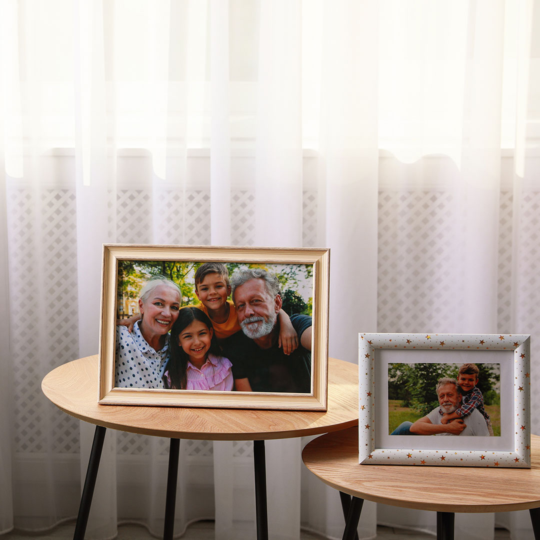 framed pictures of family members on table